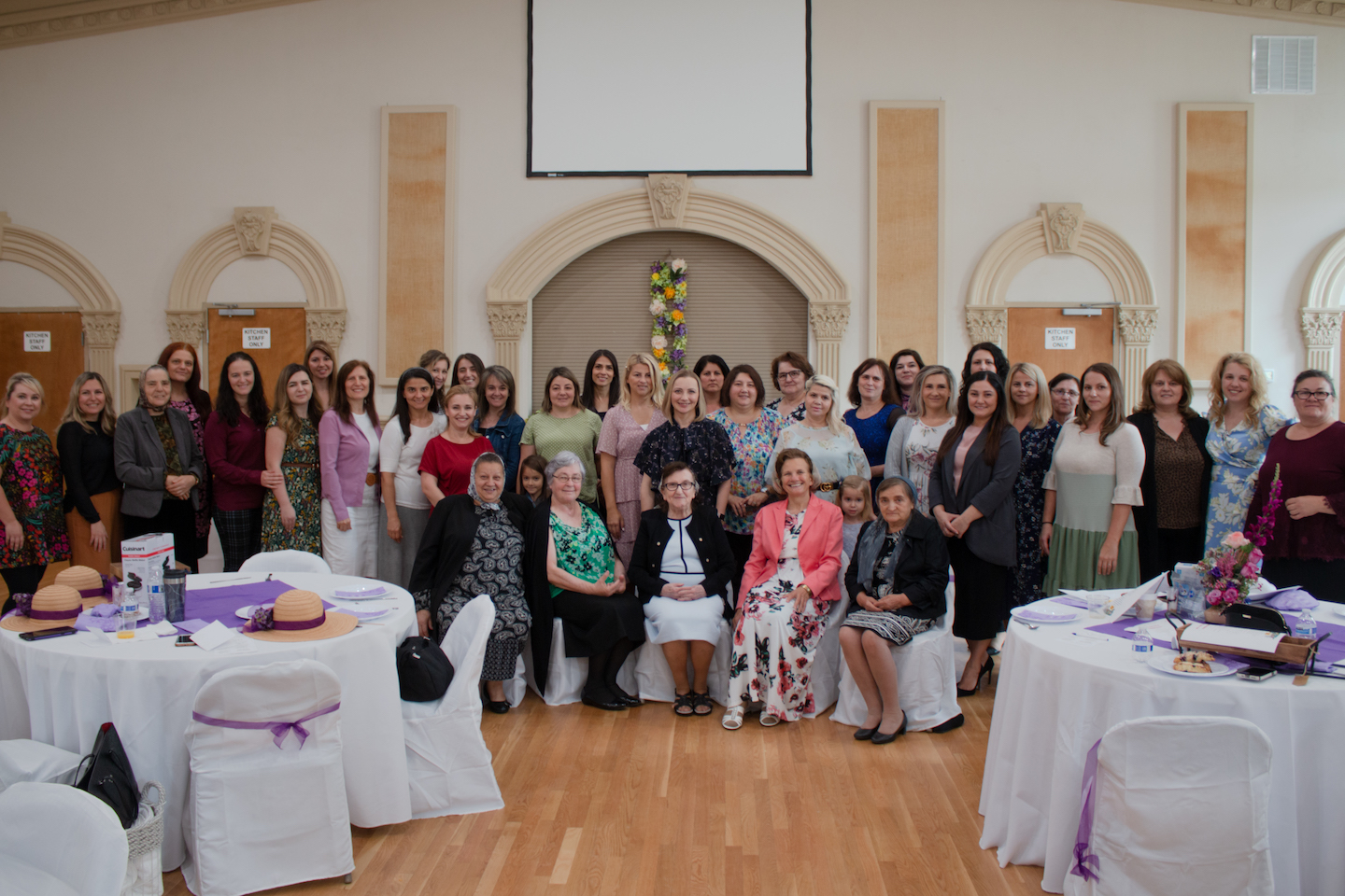 Church members gathered around decorated tables in the fellowship hall